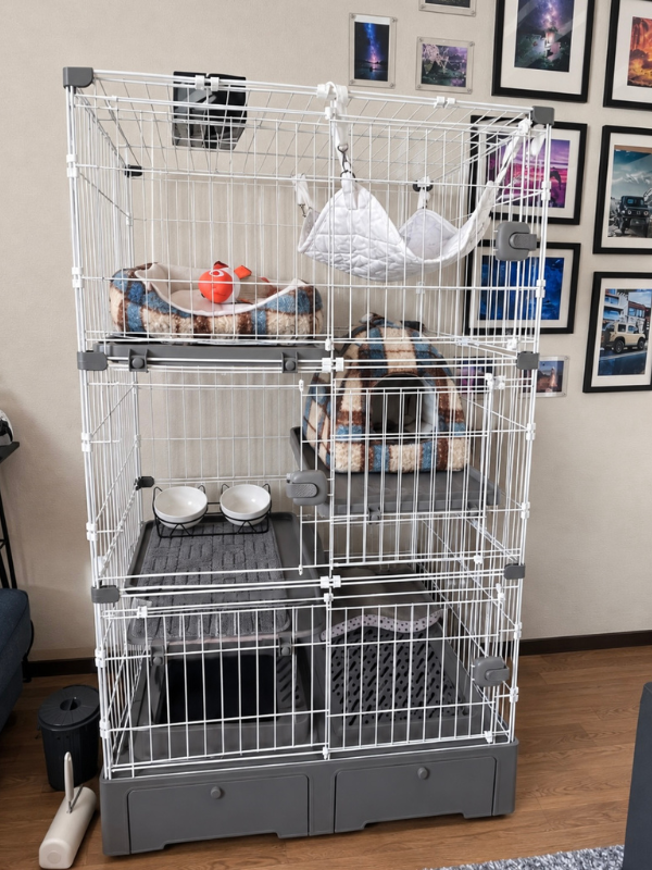 トイレ一体型の3段猫ケージ。上段にハンモックと丸いベッド、中段にドーム型ベッド、下段にフードボウルを配置
